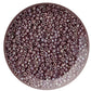 A close-up view of lavender rainbow opaque round Toho seed beads 11/0 in a circle white background.
