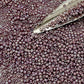 11/0 Toho Seed Beads in lavender rainbow opaque with a beading scoop