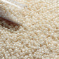 11/0 TR-123 Lt Beige Opaque Luster Round Toho Seed Beads close up with the end of a tube.