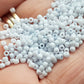 A close-up view of light grey frosted opaque pastel round Toho seed beads. 11/0 Toho Seed Beads,
