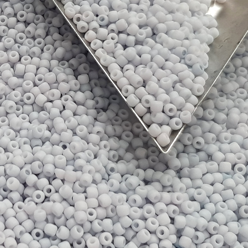 A close-up view of light grey frosted opaque pastel round Toho seed beads. 11/0 Toho Seed Beads,
Triangle scoop.