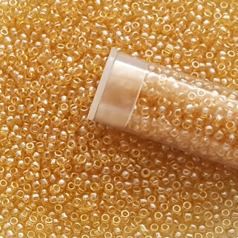 11/0 TR-103 Light Topaz Luster  Round Toho Seed Beads Close Up with a top of a tube