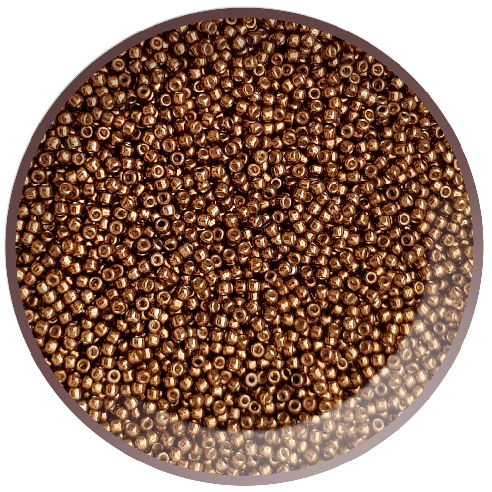 A bowl filled with round Toho seed beads in a medal bronze permanent finish. 11/0 TR-PF594 circle white background.