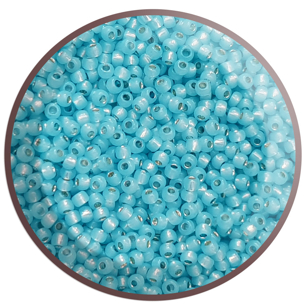 11/0 TR-2117 Milky Aqua Silver Lined Round Toho Seed Beads in a circle white background.