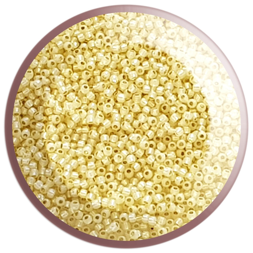 11/0 TR-2125 Milky Jonquil Ceylon Silver Lined Round Toho Seed Beads in a circle white background.