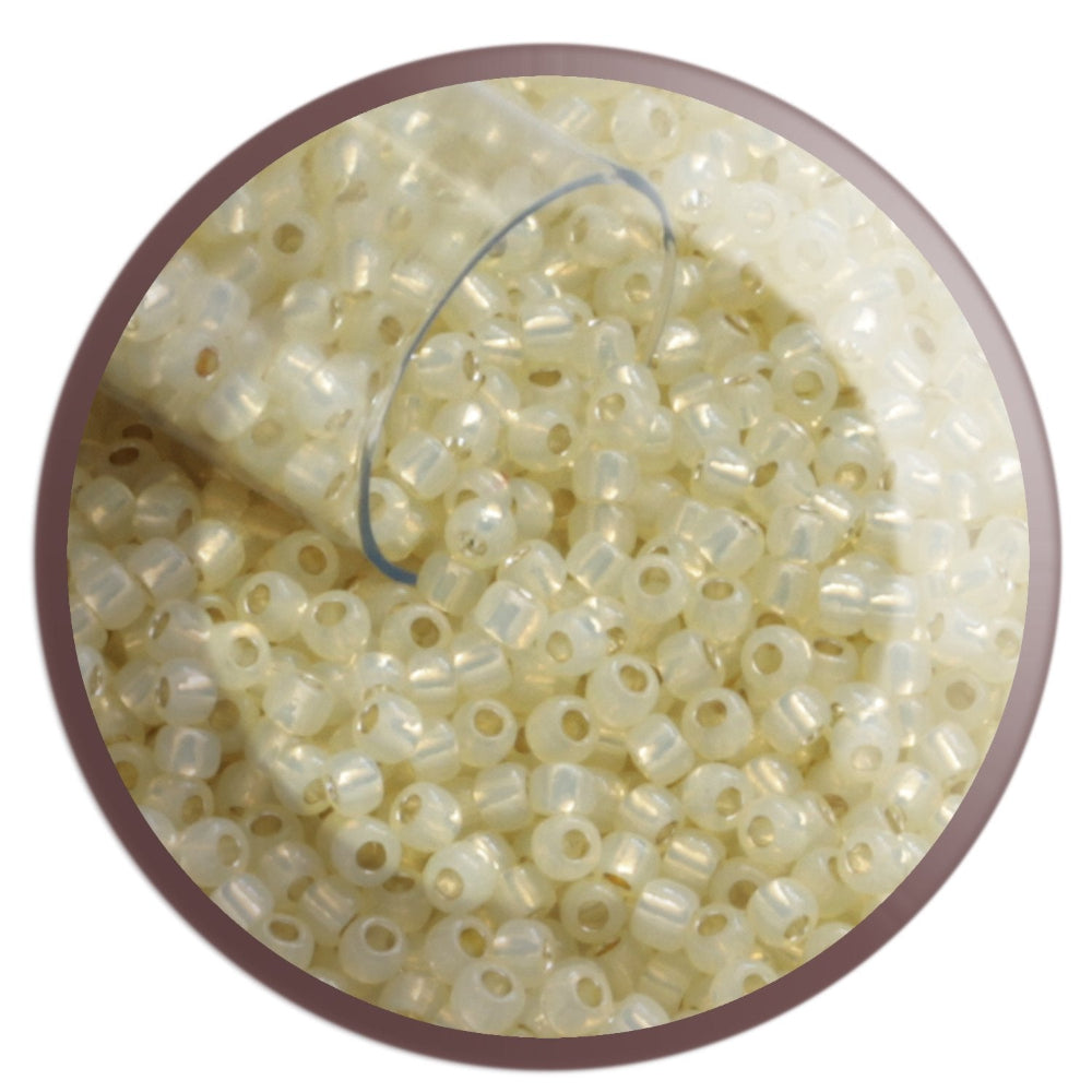 11/0 TR-2125 Milky Jonquil Ceylon Silver Lined Round Toho Seed Beads in a circle white background.