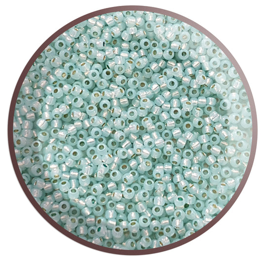 11/0 Toho seed beads in milky Lt Aqua Silver-Lined in a circle with white background.