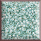 close up of milky lt aqua silver-lined Toho seed beads in a square window - 11/0