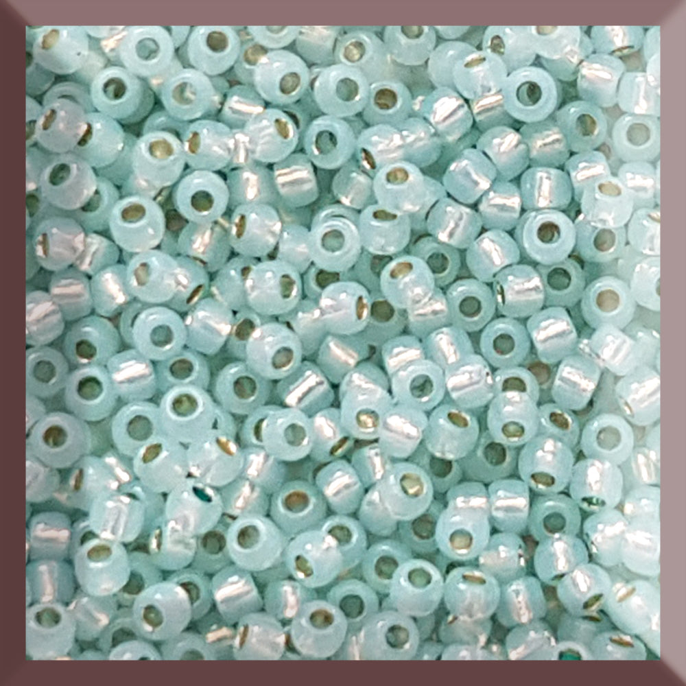 close up of milky lt aqua silver-lined Toho seed beads in a square window - 11/0