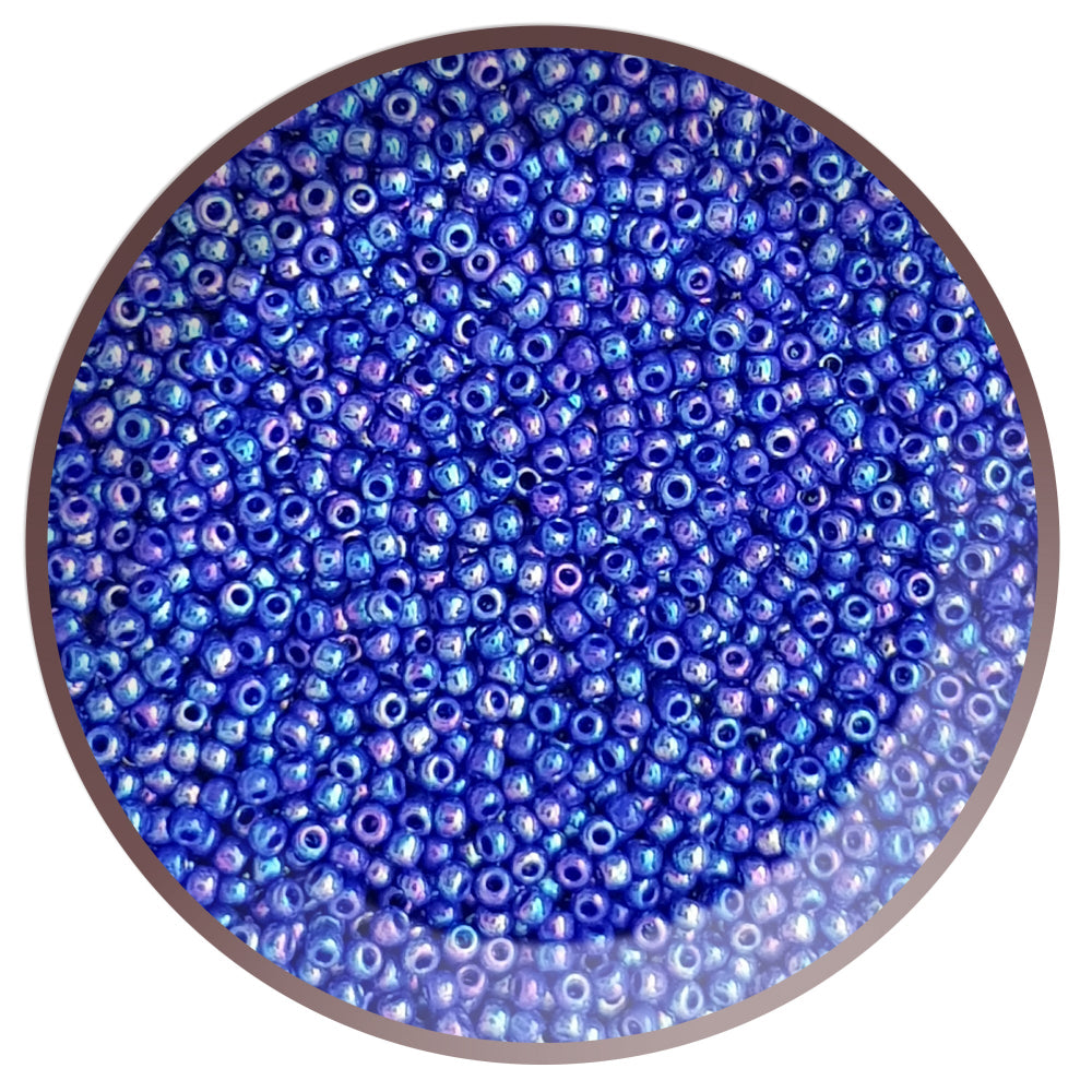 A close-up of navy blue round opaque seed beads with a rainbow sheen, arranged in a pattern.
