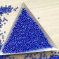 11/0 Toho seed beads in navy blue rainbow opaque with a triangle scoop.