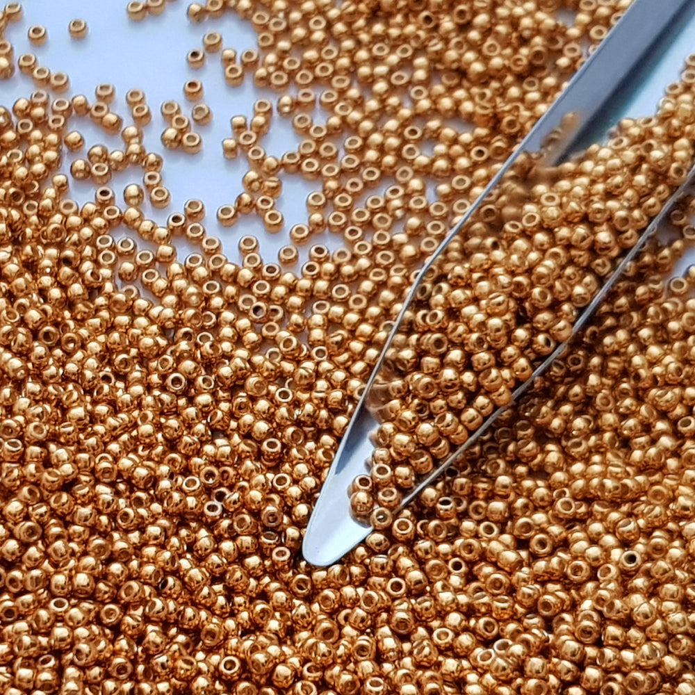 11/0 Toho Seed Beads in Old Gold Permanent Finish TR-591 with a beading scoop.