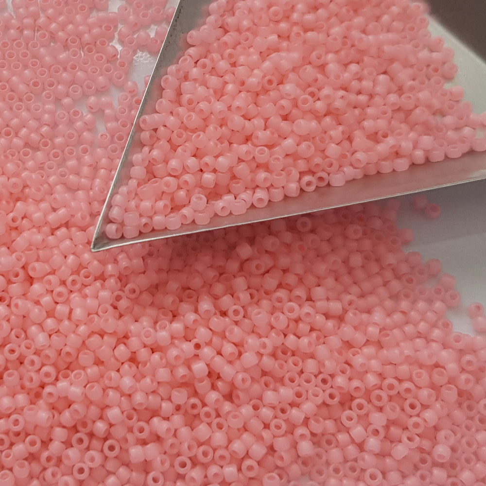 A close-up view of pink frosted round Toho seed beads.11/0  triangle scoop.