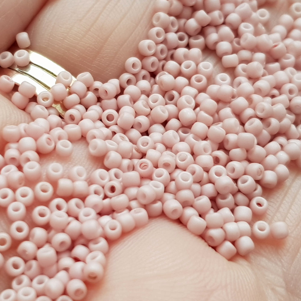 close up of Toho Seed Beads in shrimp Frosted Pastel 11/0  TR-764 on a hand