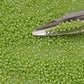 11/0 Toho Seed beads in sour apple rainbow opaque TR-404 with a beading scoop.