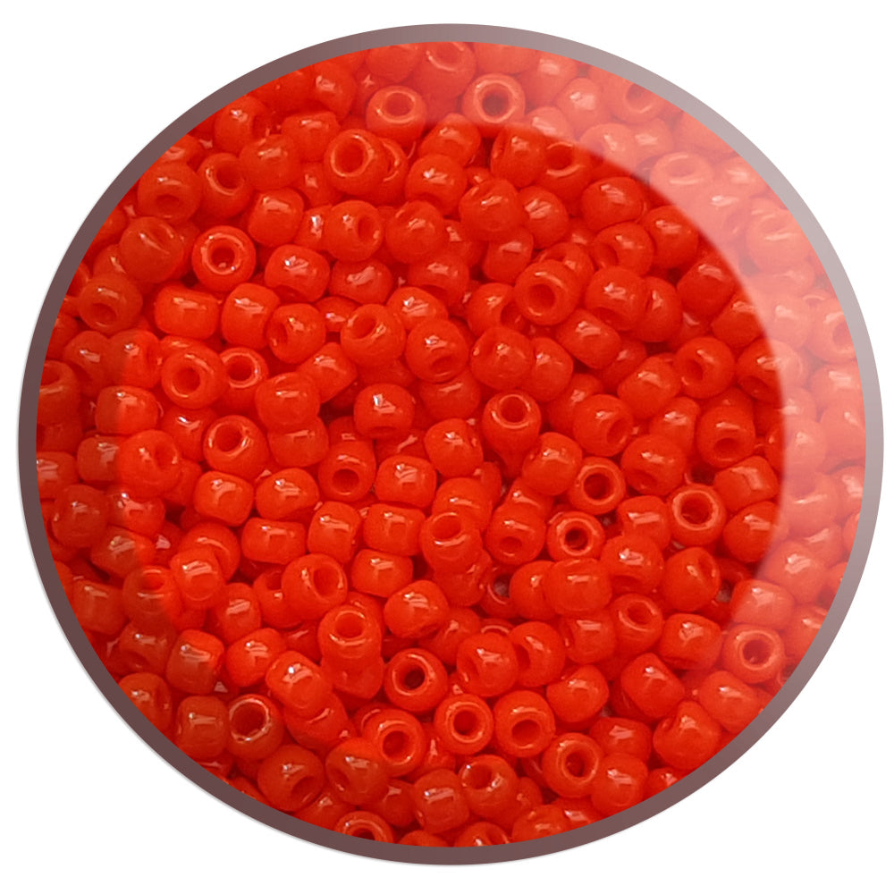 close up orange beads in a round container