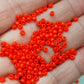 close up of orange beads on a hand
