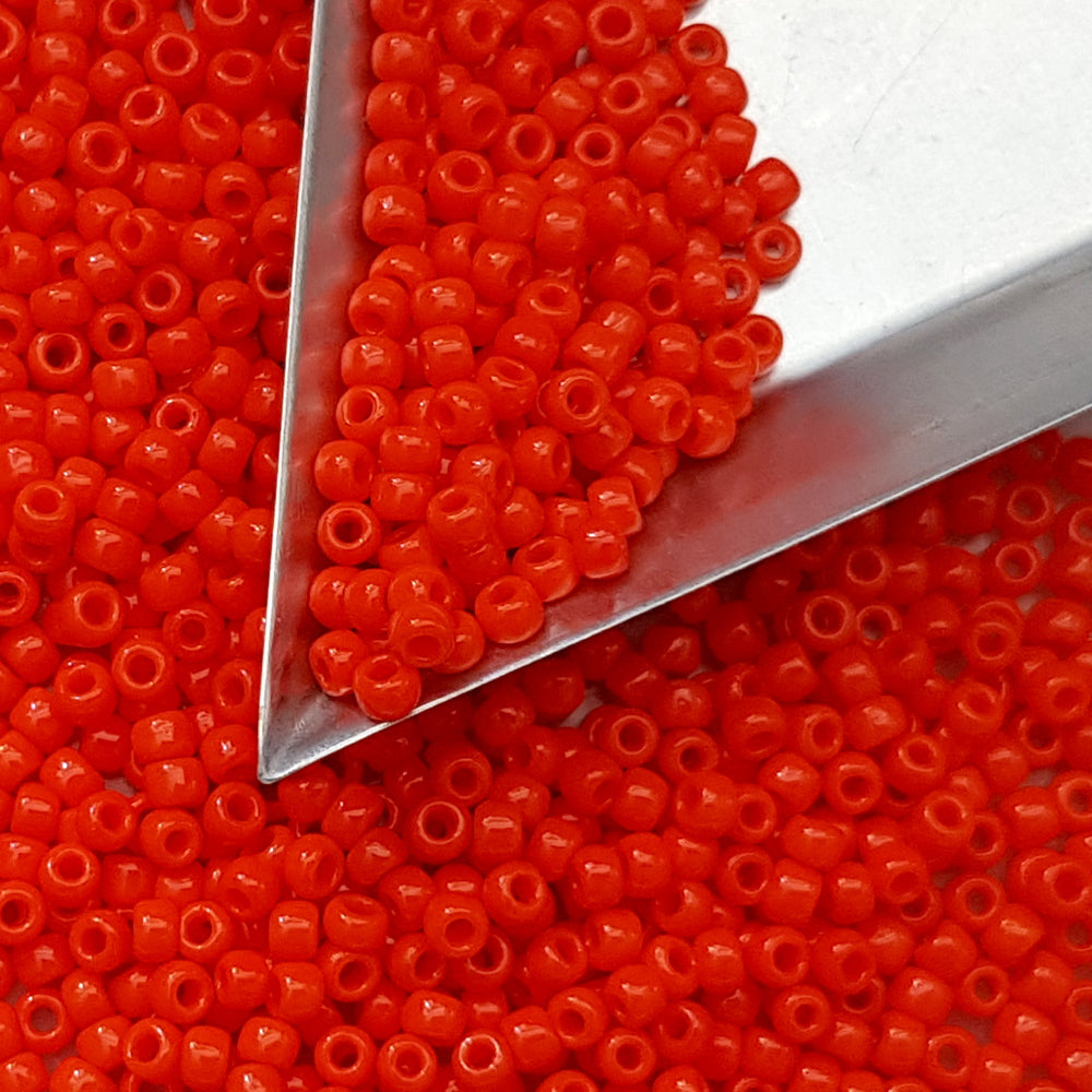 close up orange beads with a scoop