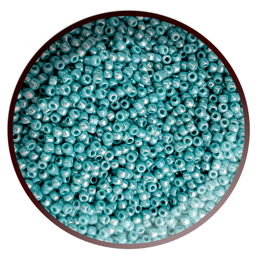 11/0 Toho seed beads in turquoise opaque rainbow in a circle white background.