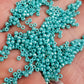 11/0 Toho seed beads in turquoise opaque rainbow on a hand