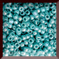 11/0 Toho seed beads in turquoise opaque rainbow in a square window.