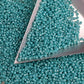 11/0 Toho seed beads in turquoise opaque rainbow with a triangle scoop.