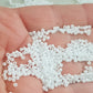 Toho 11/0 White Opaque TR-41 on a hand white background