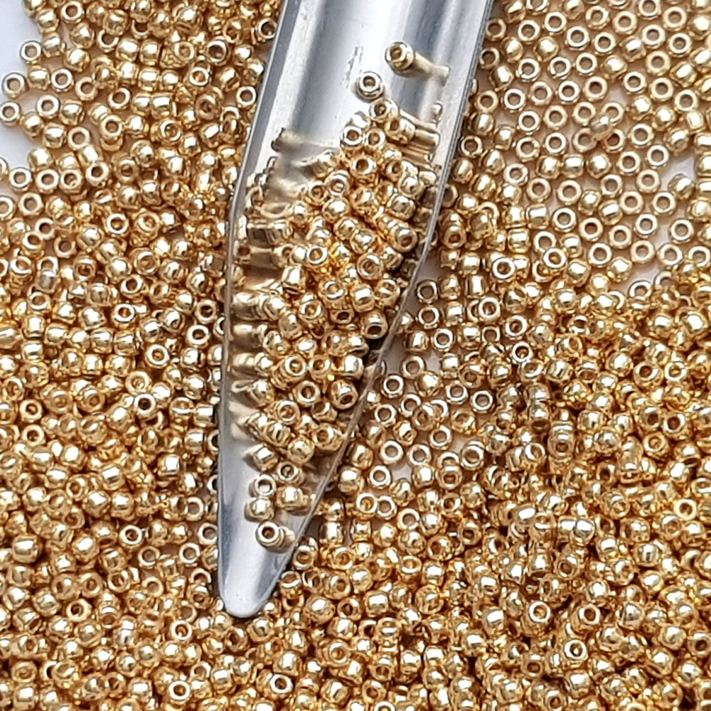 11/0 Toho Seed Beads in Starlight Gold Galvanize Permanent Finish TR-PF557 with a beading scoop.