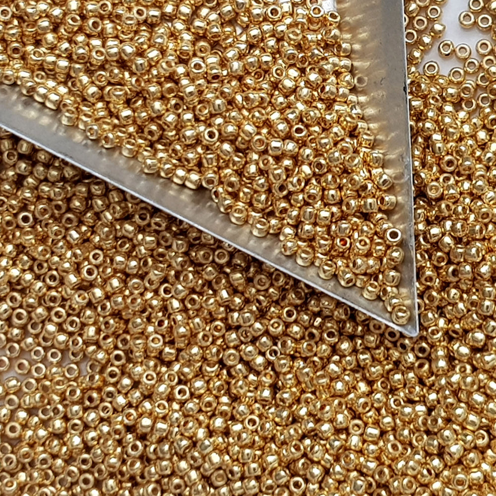 11/0 Toho Seed Beads in Starlight Gold Galvanized Permanent Finish with a triangle scoop.