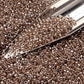 close up crystal gold-lined beads with a beading scoop.