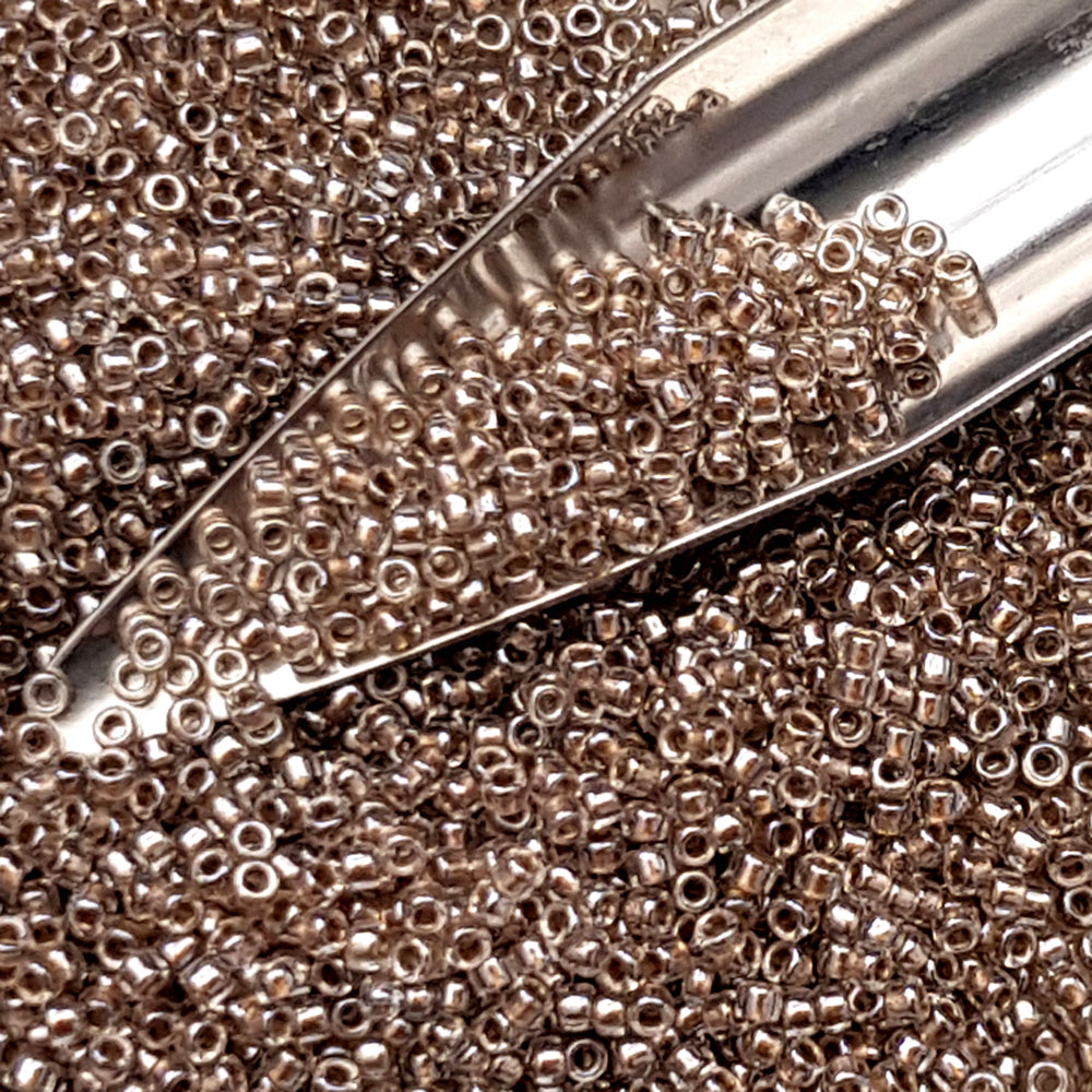 close up crystal gold-lined beads with a beading scoop.