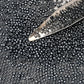 close up haematite beads with a beading scoop.