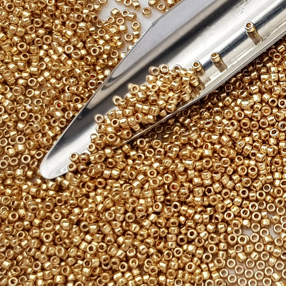 Toho 15/0 starlight gold galvanized permanent finish TR-pf557 with a beading scoop.