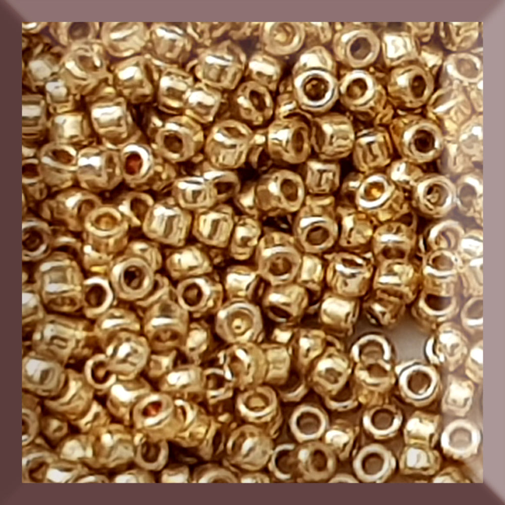 Toho 15/0 starlight gold galvanized permanent finish TR-pf557 in a square window.
