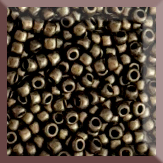 A close-up image of gold metallic round Toho seed beads with a suede hybrid finish.