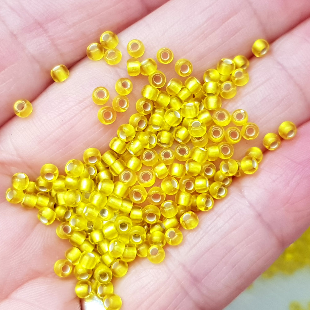 Yellow Beads Lemon frosted silver-lined 8/0 tr-32F on a hand.