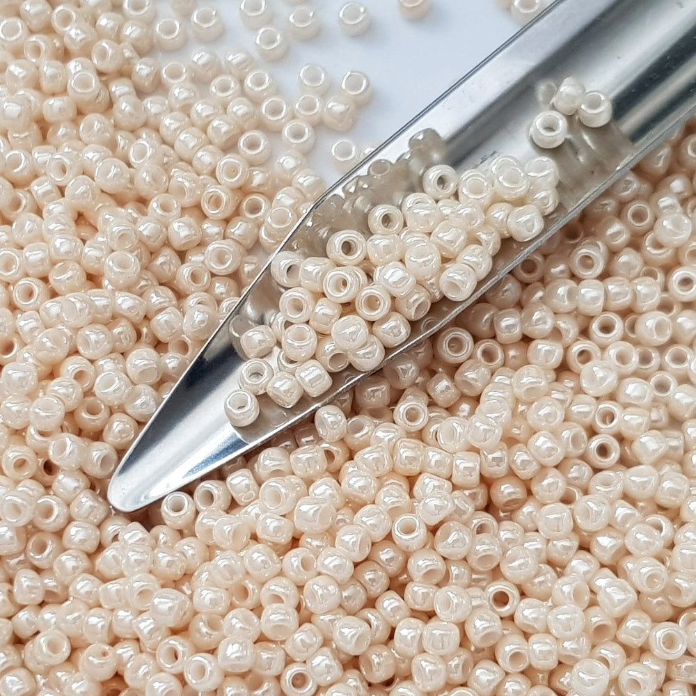8/0 Toho Seed Beads in Lt Beige Luster Opaque TR-123 with a beading scoop.