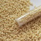 8/0 TR-51 Lt Beige Opaque Round Toho Seed Beads - close up with a tube
