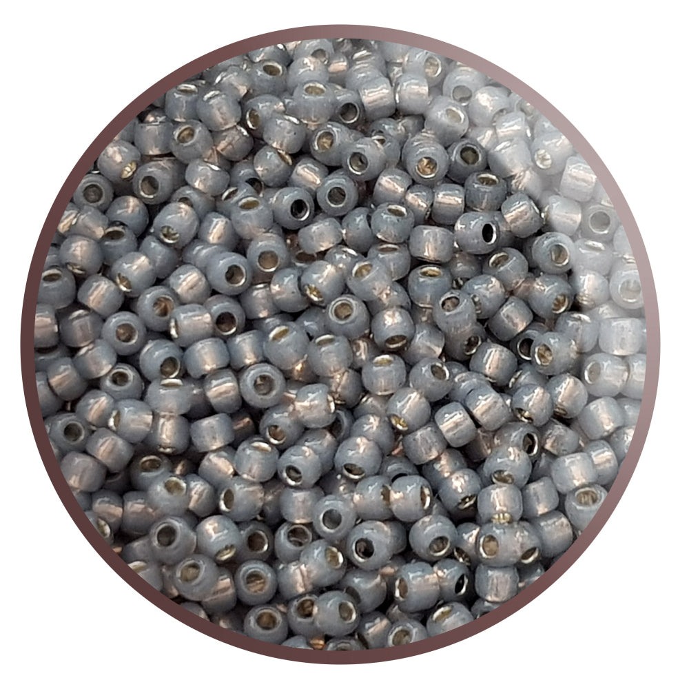 8/0 Toho Seed Beads in Milky Grey Silver-Lined TR-2115 in a circle white background.