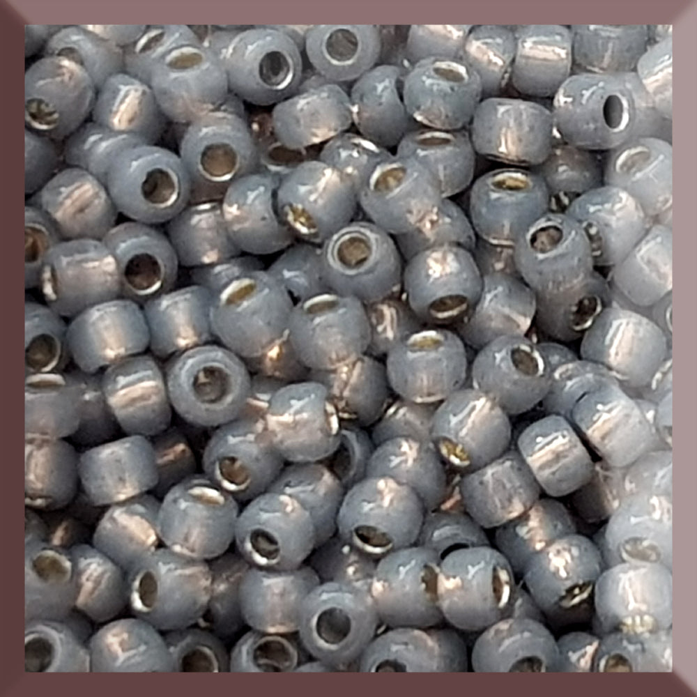 A close-up of Milky Grey Silver-Lined 8/0 Round Toho Seed Beads TR-2115 used for beading and jewelry making.