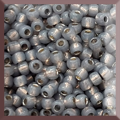 A close-up of Milky Grey Silver-Lined 8/0 Round Toho Seed Beads TR-2115 used for beading and jewelry making.