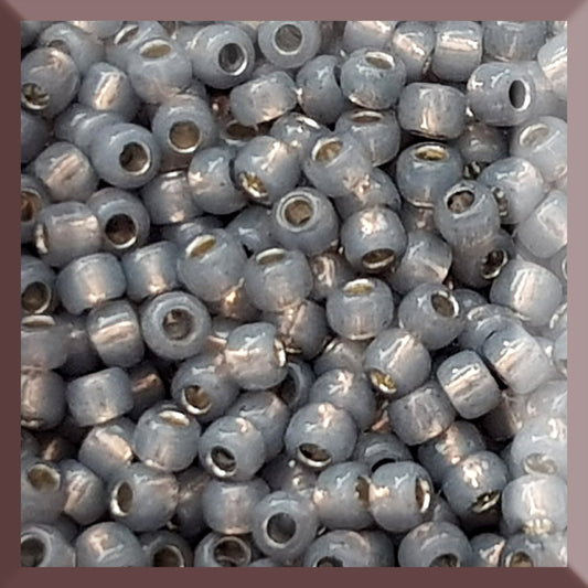 A close-up of Milky Grey Silver-Lined 8/0 Round Toho Seed Beads TR-2115 used for beading and jewelry making.