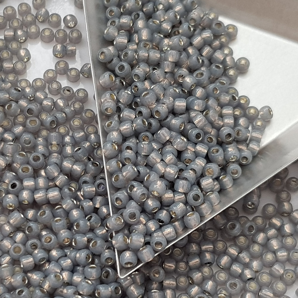 8/0 Toho Seed Beads in Milky Grey Silver-Lined TR-2115 with a triangle scoop.