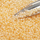 8/0  Toho Seed beads in peach cobbler ceylon TR-148 with beading scoop.