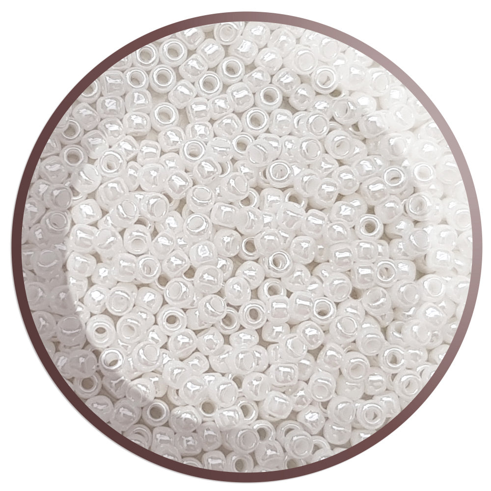 8/0 Toho  seed beads in white luster opaque in a circle white background.