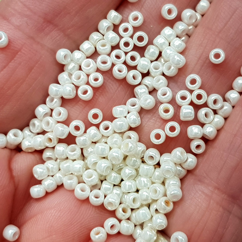 8/0 Toho seed beads in white Navajo luster Opaque TR-122 close on a hand.
