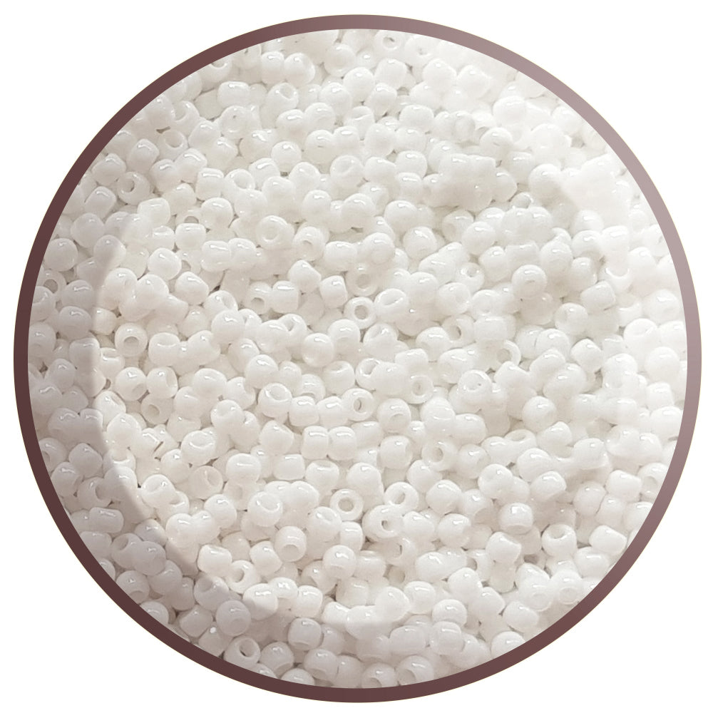 8/0 Toho seed beads in white opaque in a circle white background.