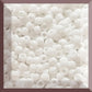 A close-up image of white opaque round Toho seed beads Square window.