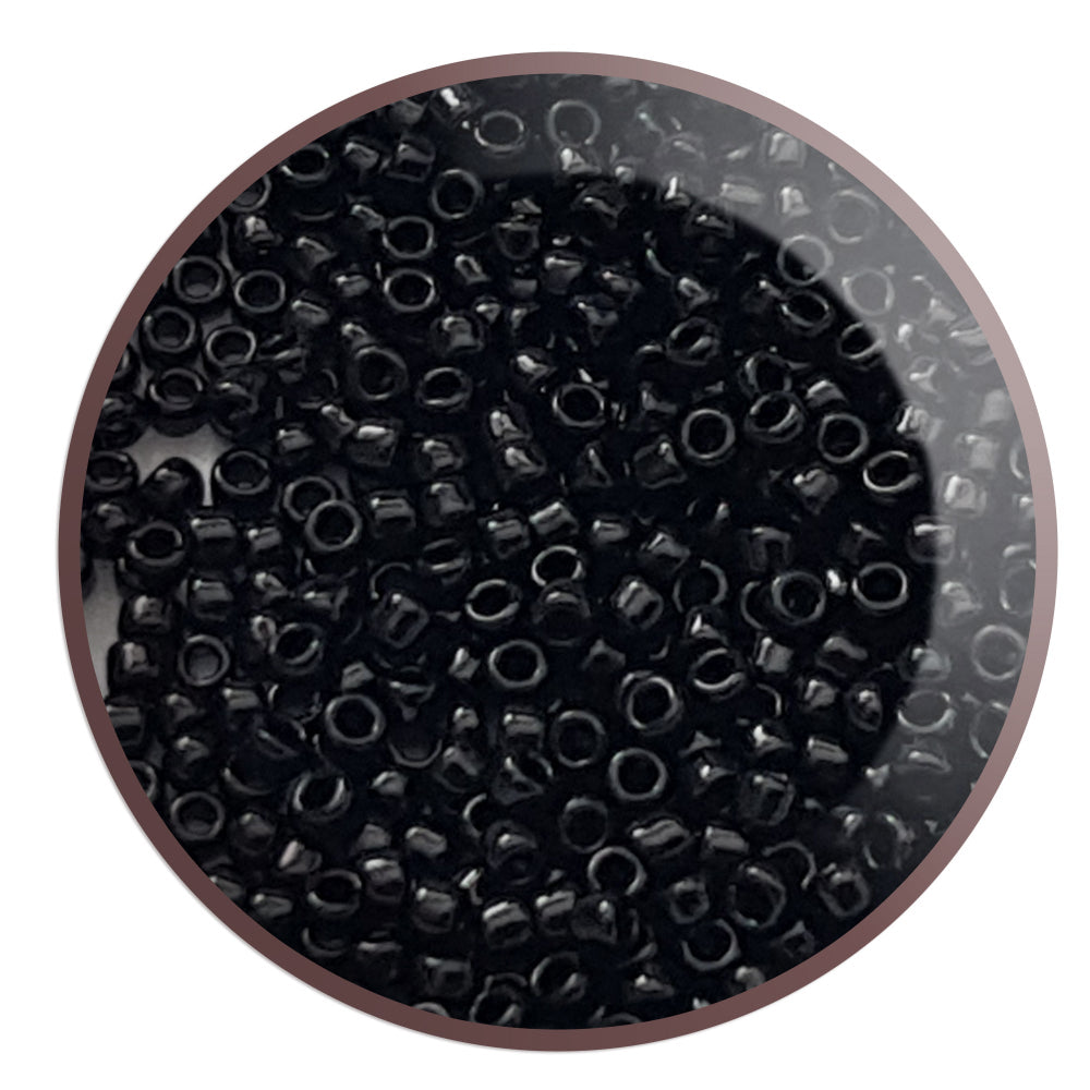 Toho seed beads 15/0 jet black opaque TR-49 in a circle white background.