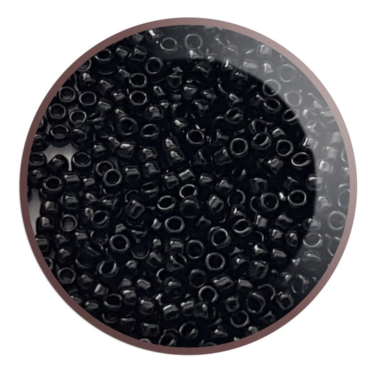 Toho seed beads 15/0 jet black opaque TR-49 in a circle white background.